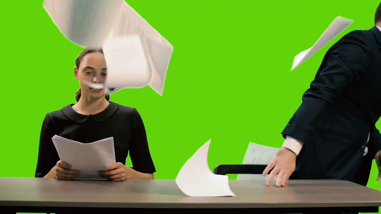 Young beautiful TV presenter and stylish young man are hosting a news TV channel. The young man gets angry, throws the papers and leaves the frame. Chromakey.