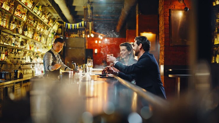 Persone che bevono, si rilassano in un pub e si godono delle sigarette al tabacco con luci soffuse. Coppia che fa festa