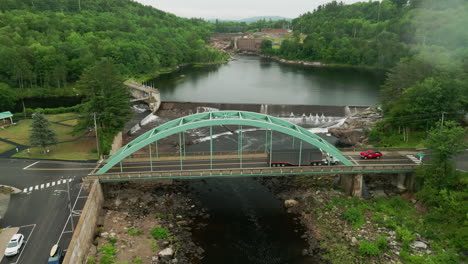 aerial footage of androscoggin river and dam with green bridge in rumford, maine