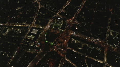 AERIAL:-Slow-Overhead-Shot-of-City-at-Night-with-Lights-and-Traffic,-Cologne,-Germany