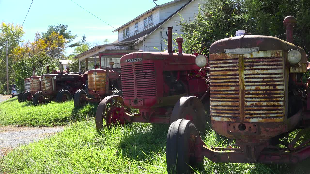 오래된 빈티지 트랙터가 시골 지역의 집 앞마당에 앉아 있다