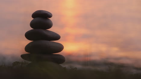 una mano pone una piedra encima de una torre de piedras concepto de armonía y equilibrio