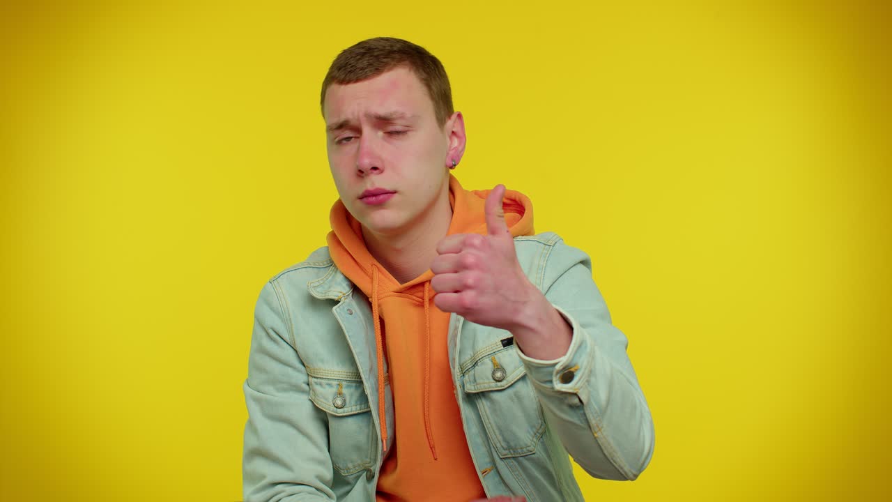 십대 남자 는 엄지 손가락 을 들여서 동의 하거나 긍정적 인 대답 을 한다. 광고 를 추천 한다.