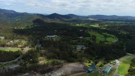 hinze dam gold coast ,drone footage of rock wall with hinterland landscape, dramatic reveal as drone pulls back