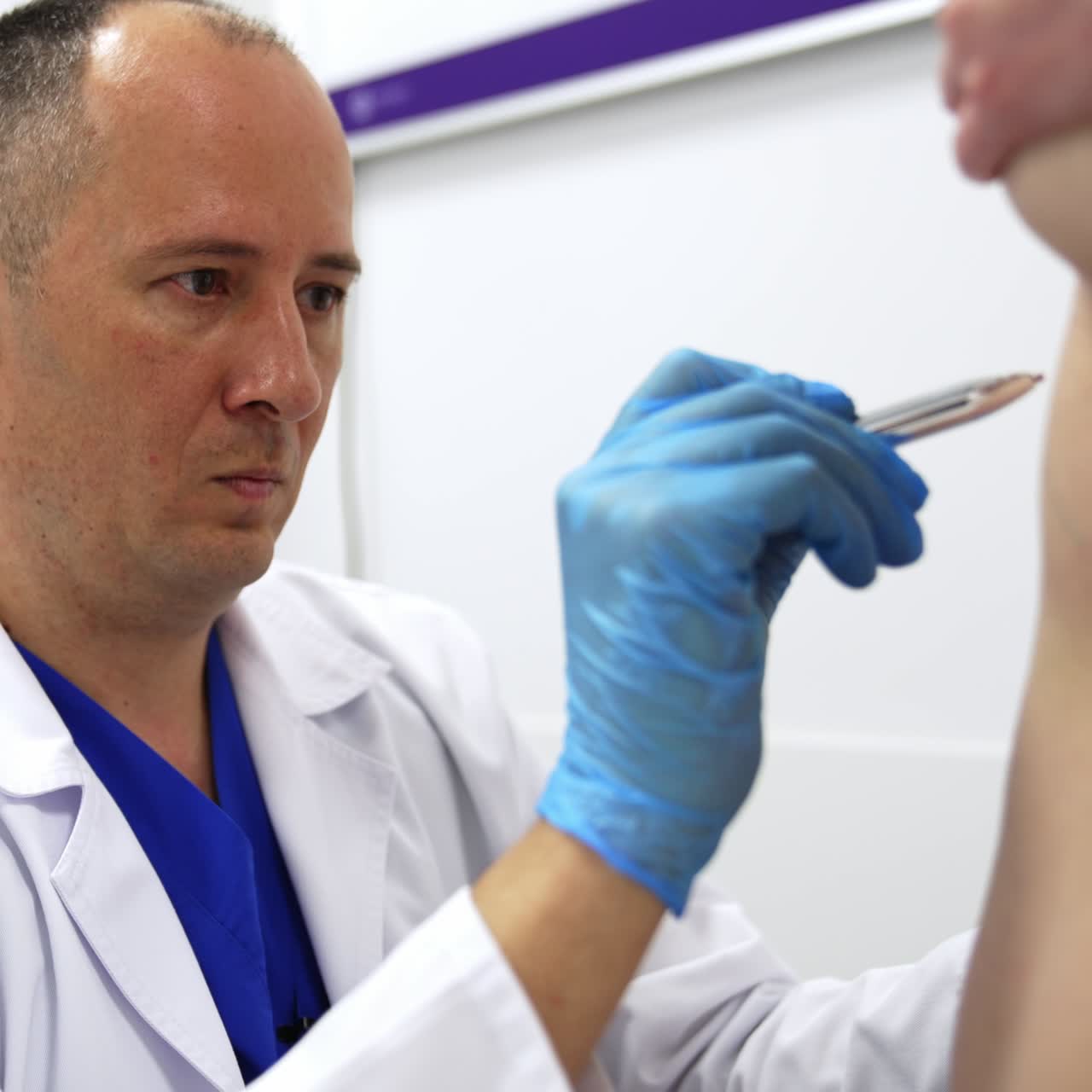 Médico concentrado desenhando linhas no abdômen da paciente. Especialista profissional preparando a mulher para cirurgia de lipoaspiração.