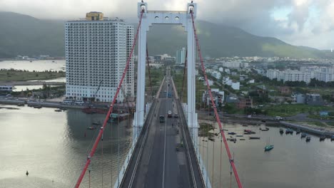 aerial shot of flying underneath the arches of a suspension bridge in danang, vietnam