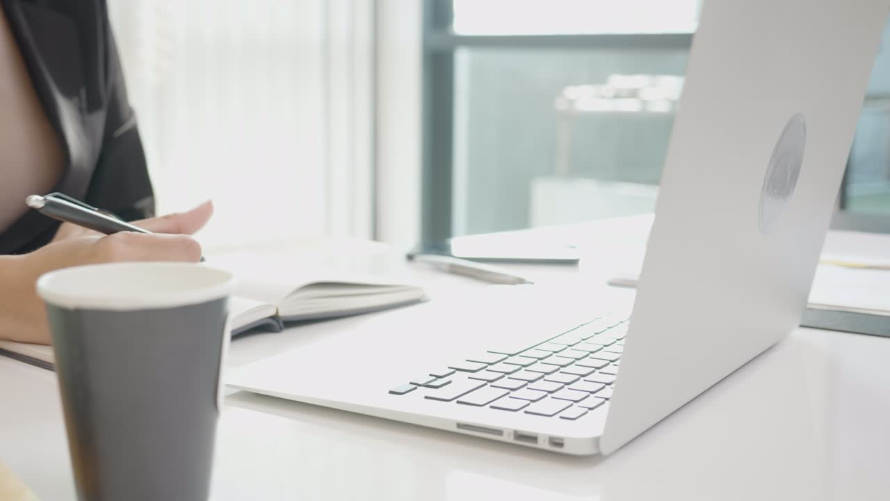 노트북, 직원 및 회계, 비즈니스 및 커뮤니케이션 개념을 사용하여  컴퓨터에서 키보드를 입력하고 사무실, 임원 또는 매니저에서 메모를 작성하는 젊은 여성의 클로즈업 손.