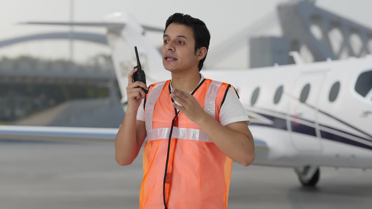trabajador del personal de tierra del aeropuerto indio dando instrucciones en walkie talkie