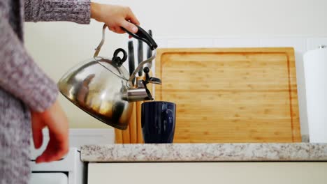 mid section of woman pouring coffee in mug