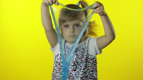 niño jugando con lodo de juguete hecho a mano. niña divirtiéndose haciendo lodo de turquesa. antistress