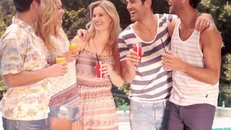 happy friends drinking by the pool