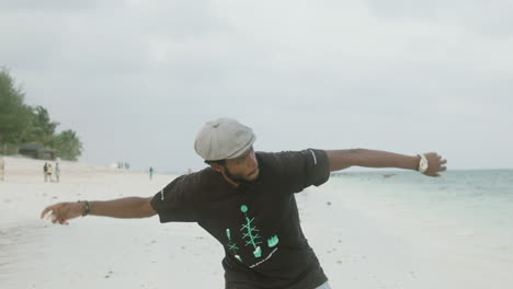 slow motion shot of a young black boy on the beach playing pebble toss in the sea