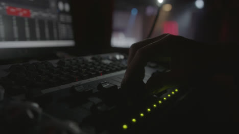 increíble disparo en cámara lenta del detalle de una mano de un espectáculo en vivo ingeniero de sonido moviendo un desvanecimiento de la mesa de sonido miviendo las luces del escenario