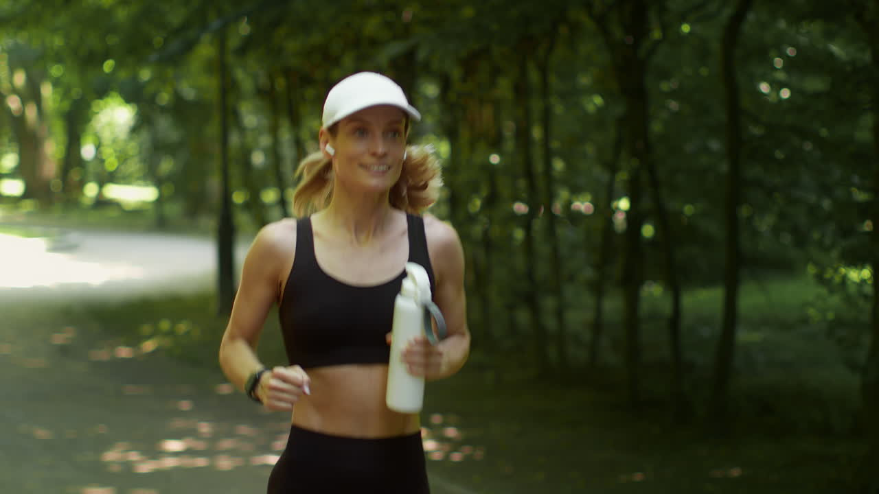 Woman Jogging in a Park with a Water Bottle