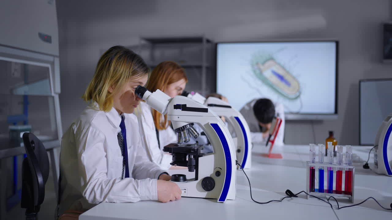 estudiantes en un laboratorio de ciencias usando microscopios