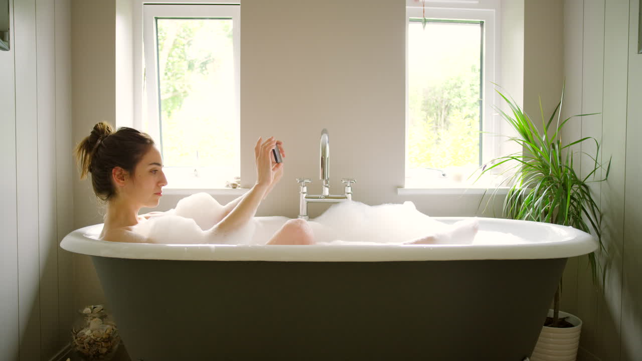 거품 욕조에서 셀피를 찍는 여자