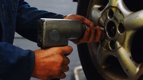 Mechanic-using-bolt-tightening-machine-in-garage-4k