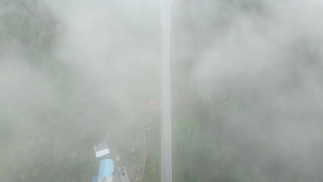 el avión no tripulado ariel ve la puesta de sol de la mañana con niebla y bosque verde en el enlace de la carretera costera de sempadi sarawak, borneo.