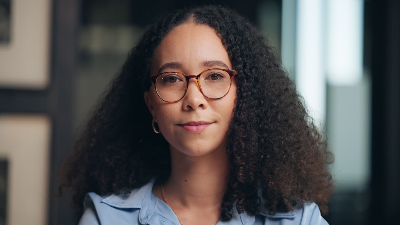 Portrait of a smiling woman with curly hair wearing eyeglasses