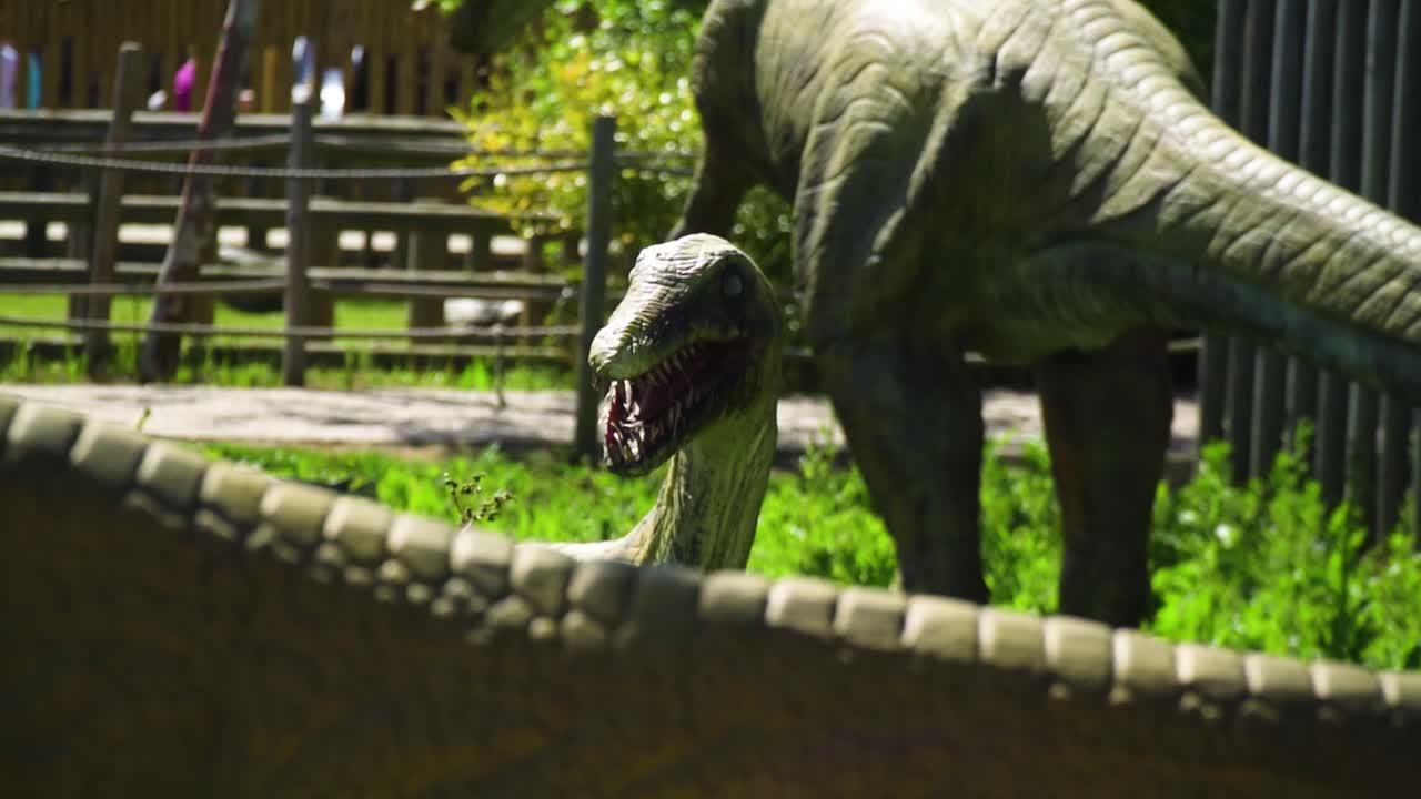 그의 먹이 음식 슬로우 모션을 보고 디노 공원에서 얼굴을 위협 하는 피 묻은 이빨을 가진 무서운 공룡 모델 공개