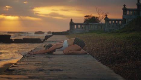 slim attractive young female doing yoga child pose during holiday retreat