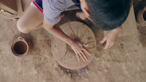 child potter working on pottery wheel