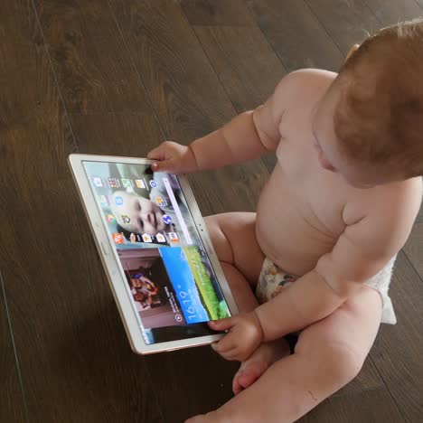baby girl playing with a digital tablet