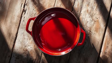 red dutch oven on rustic wooden table