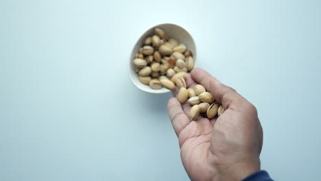 Hand picking pistachios from a bowl