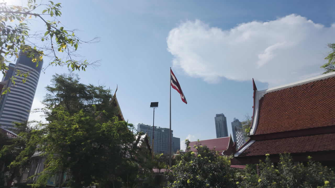 Bandiera thailandese sventolante al tempio buddista Wat Uthai Tharam a Bangkok, in Thailandia. Ripresa POV