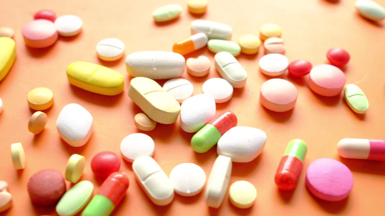 오렌지색 표면에 있는 다양한 색의 알약