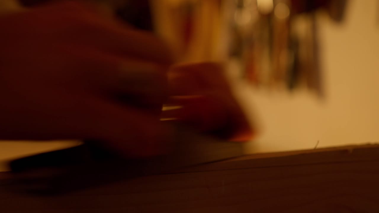 보드에서 부스러기가 나오는 동안 샌딩되는 나무 보드의 클로즈업