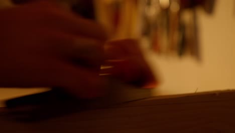 primer plano de una tabla de madera que se lija mientras las virutas salen de la tabla