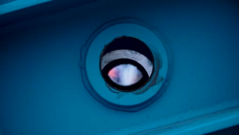 close-up of a blue industrial component with a round hole