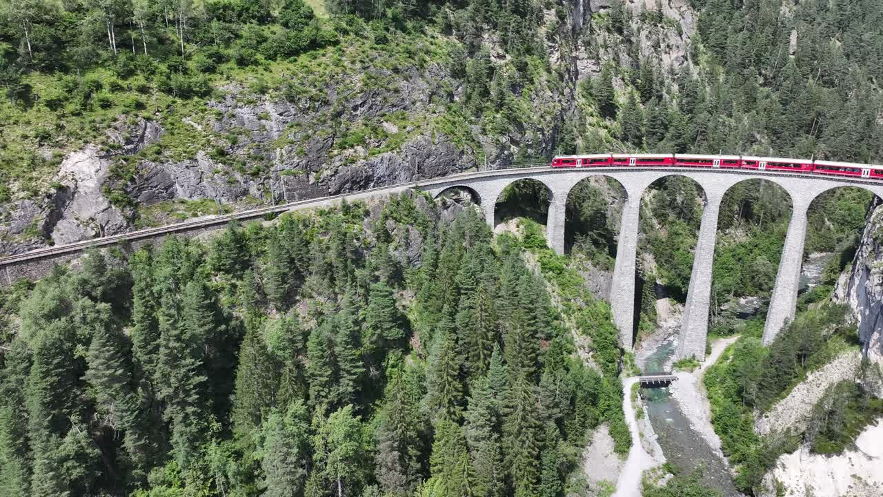 vista aérea del viaducto de landwasser mientras un tren rojo cruza el puente, mostrando la impresionante ingeniería del viaduto