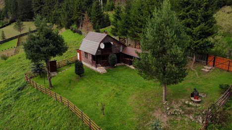 a small house with a wooden fence in the forest