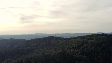 amplia antena ascendente de bosque montañoso y ciudad distante en europa central