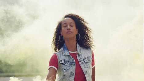 mujer joven de moda en el techo urbano usando una granada de humo