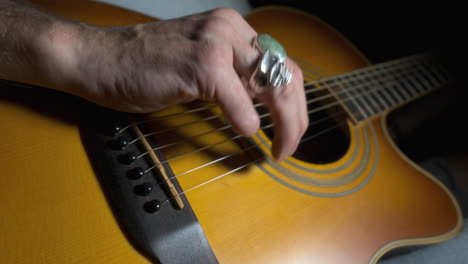 amputee playing acoustic guitar with crop in to missing fingers