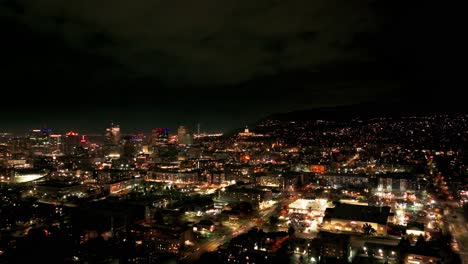 Nighttime-drone-shot-flying-over-downtown-Salt-Lake-City-towards-capital