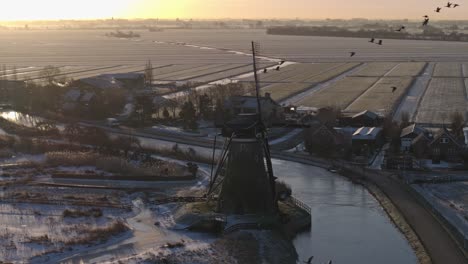 dutch winter landscape with windmill at sunrise