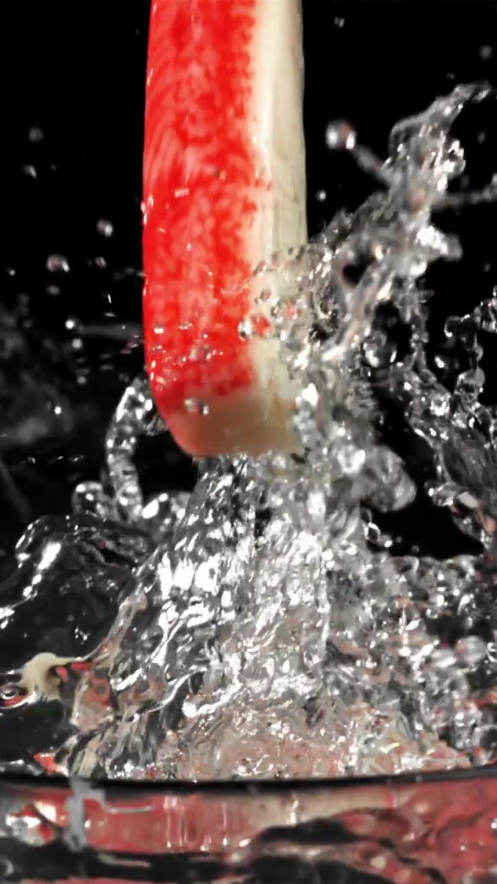 Bastoncini di granchio che cadono nell'acqua e schizzano al rallentatore