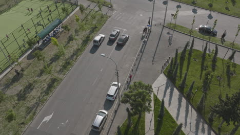 toma aérea de autos parando en semáforos con cruce de peatones