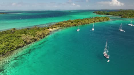 various islands of vava'u nestled on azure water in tonga during daytime. aerial, pull-back shot