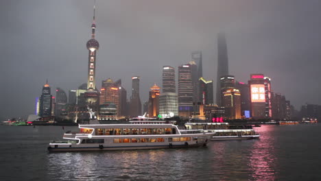 the vivid night skyline of shanghai china with river traffic foreground 1