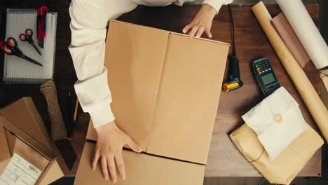 e-commerce storage shop, woman packing goods and clothes for second hand delivery market, dedicated packaging and shipping workspace with supplies and technology for efficiency, online sales.
