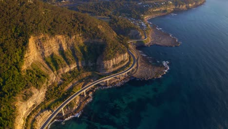 Vista-Aérea-Del-Puente-Sea-Cliff-Junto-Al-Puente-Lawrence-Hargrave-Drive-A-Lo-Largo-Del-Mar-Azul-En-Nsw,-Australia