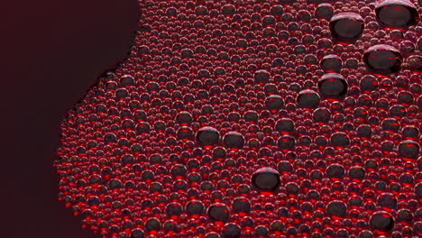 sizzling foam red liquid surface closeup. bubbled rose wine texture top view