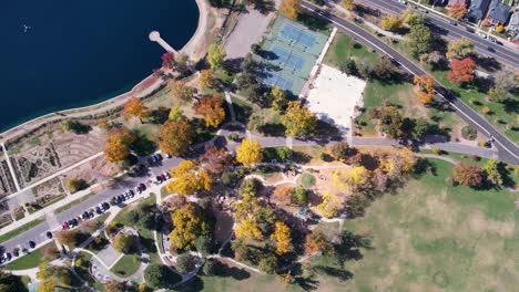 a 4k drone shot over washington park and tennis courts, mount vernon garden, and grasmere lake, in denver, colorado, on a peaceful day, during the colorful fall season