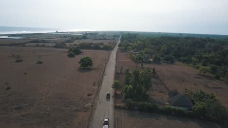 antena de drones, vehículos 4x4 conduciendo por la carretera junto a la arena hacia la playa en monterrico, guatemala, américa central